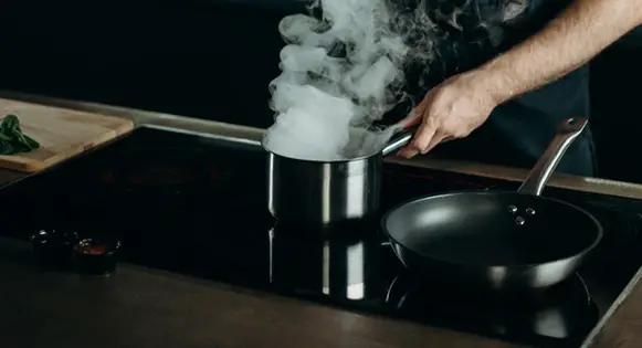 A pot and a pan on a glass top stove