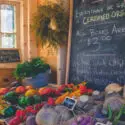 Organic produce for sale with a chalkboard sign showing prices