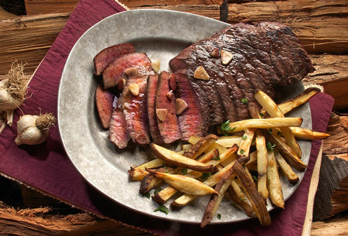 Image of medium rare steak with french fries