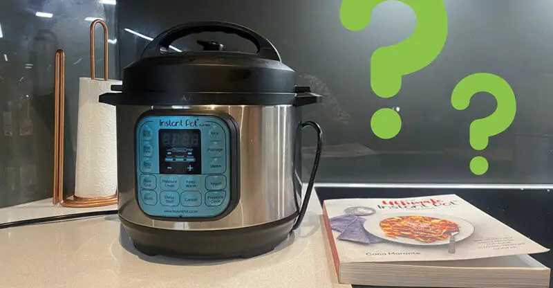 Instant Pot with cookbook on top of a modern kitchen cooktop