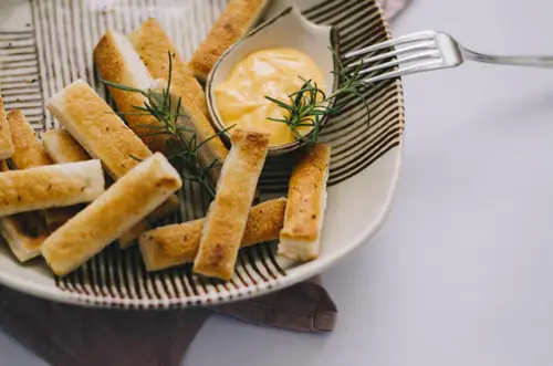Rustic breadsticks in a plate with dip