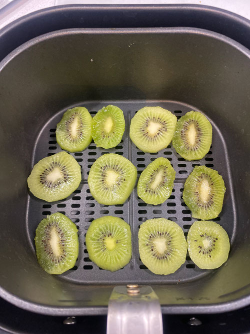 kiwi slices placed in a Philips Air Fryer, ready for dehydration